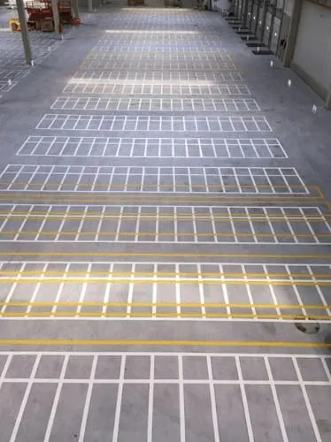 Rows of parking bays marked in white and yellow on a concrete deck