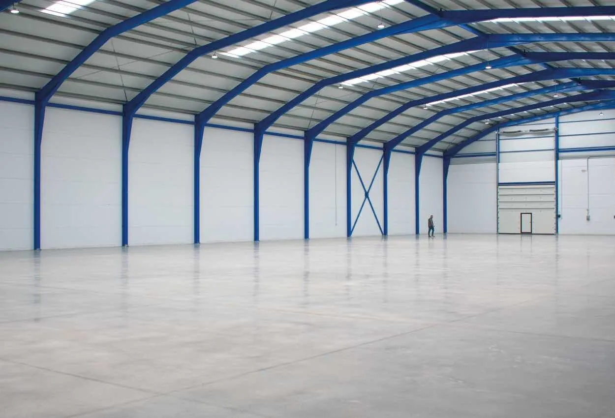 Halle de stockage vide à charpente métallique, prête à recevoir des marchandises