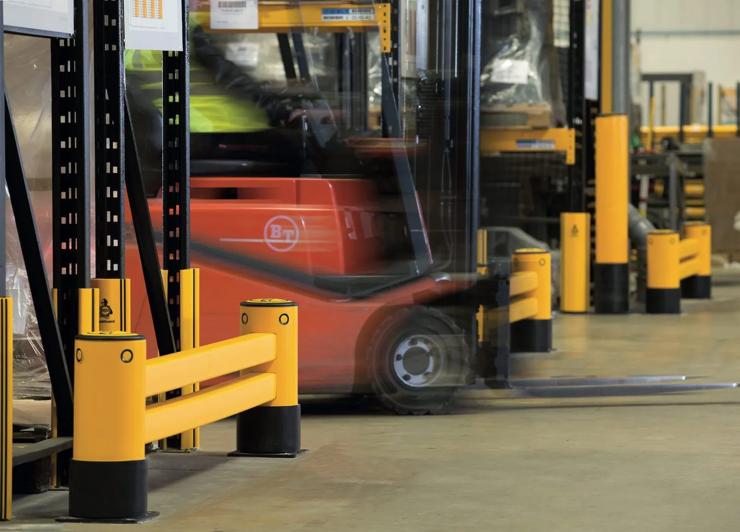 Forklift working behind a yellow impact barrier set around a structural column