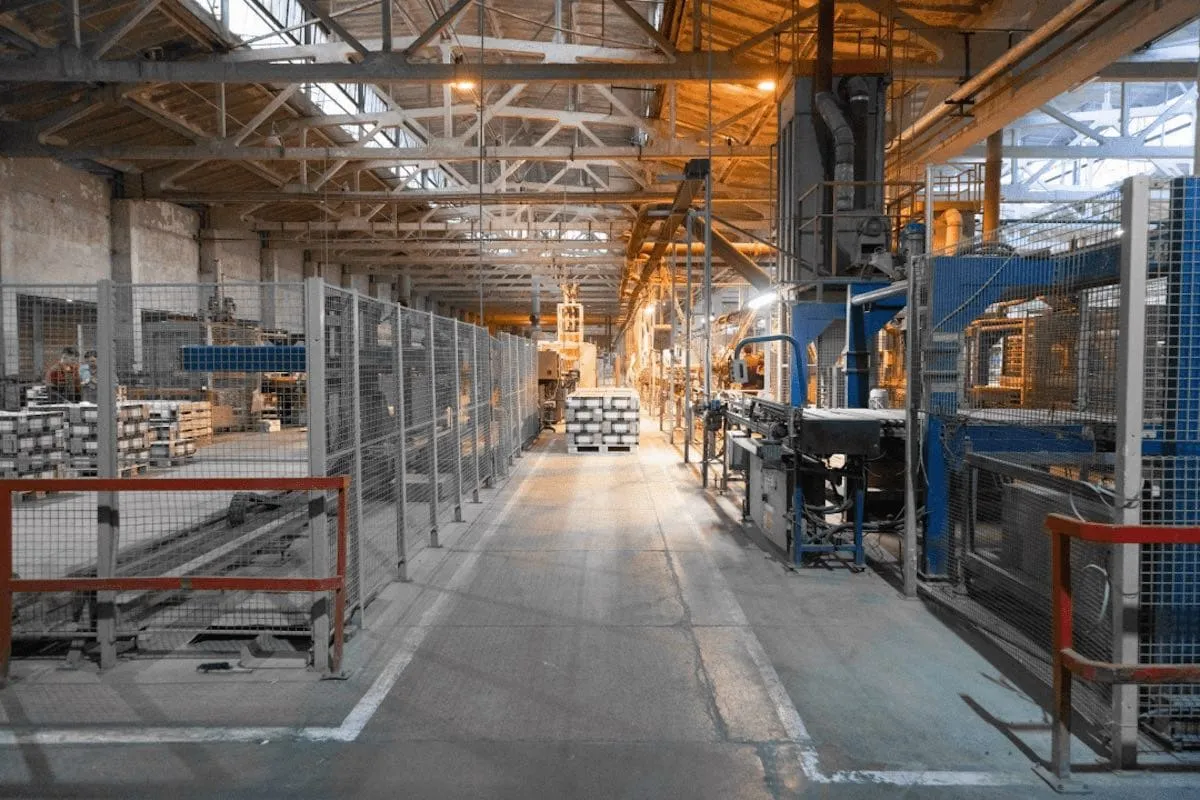 Mesh fencing running the length of a production line inside a factory