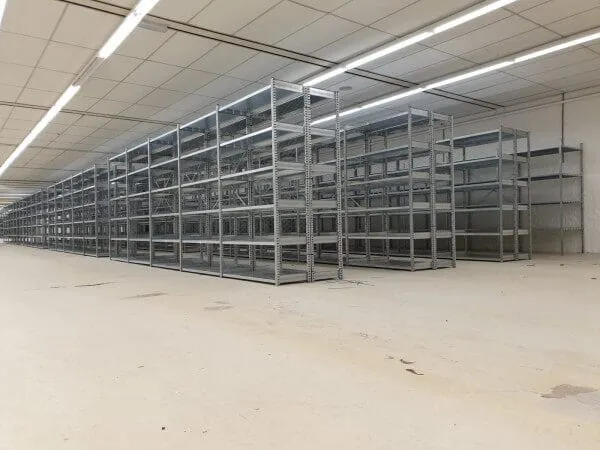 Rijen legbordstellingen in een lege magazijnruimte
