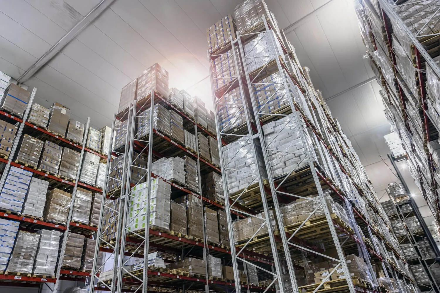 Hoge stellingen met gewikkelde pallets in een koel magazijn