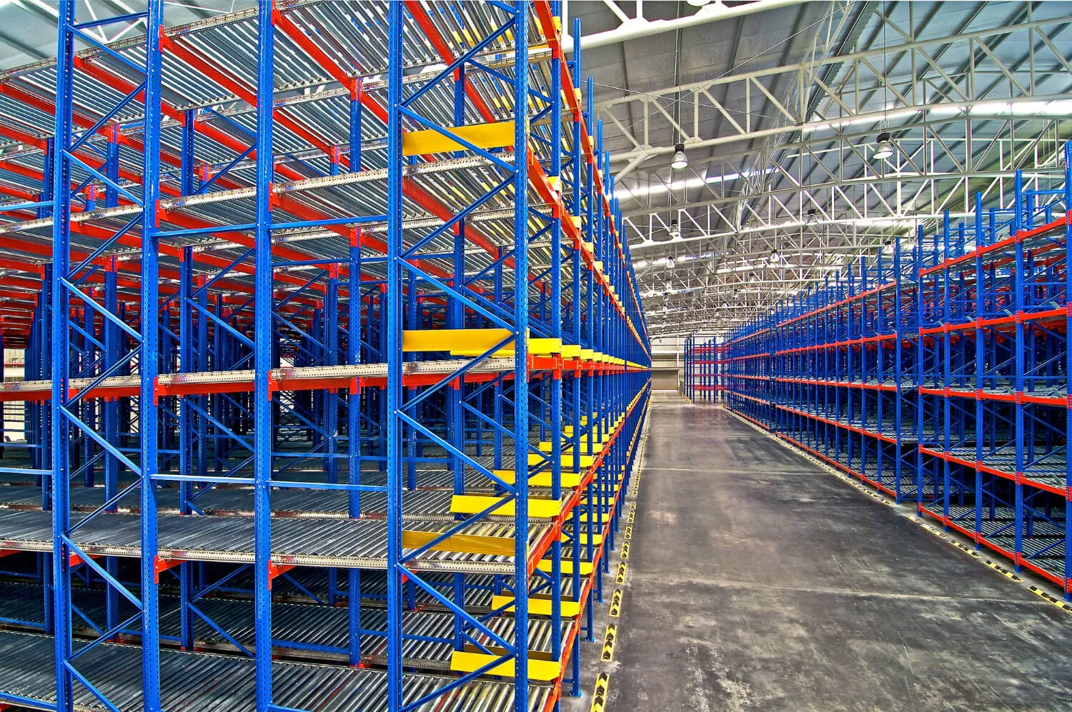 Installers assembling pallet racking uprights and beams in a warehouse