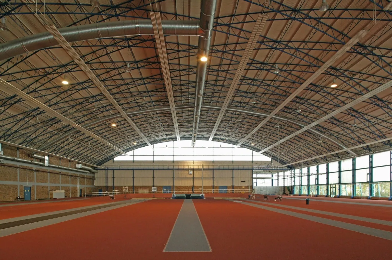 Radiant heating strips under the arched roof of an indoor athletics hall