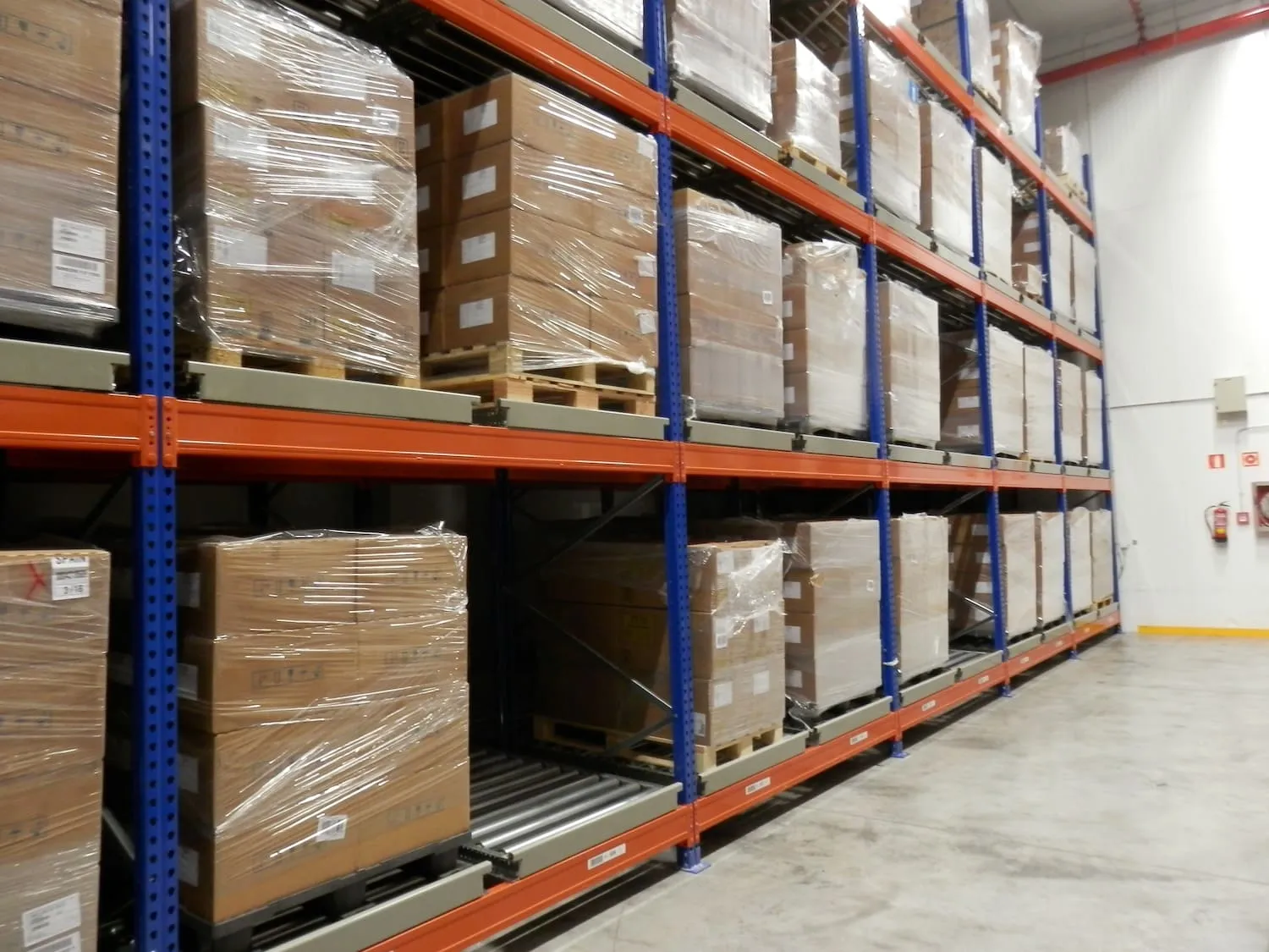 Push-back racking with pallets resting on inclined roller carts