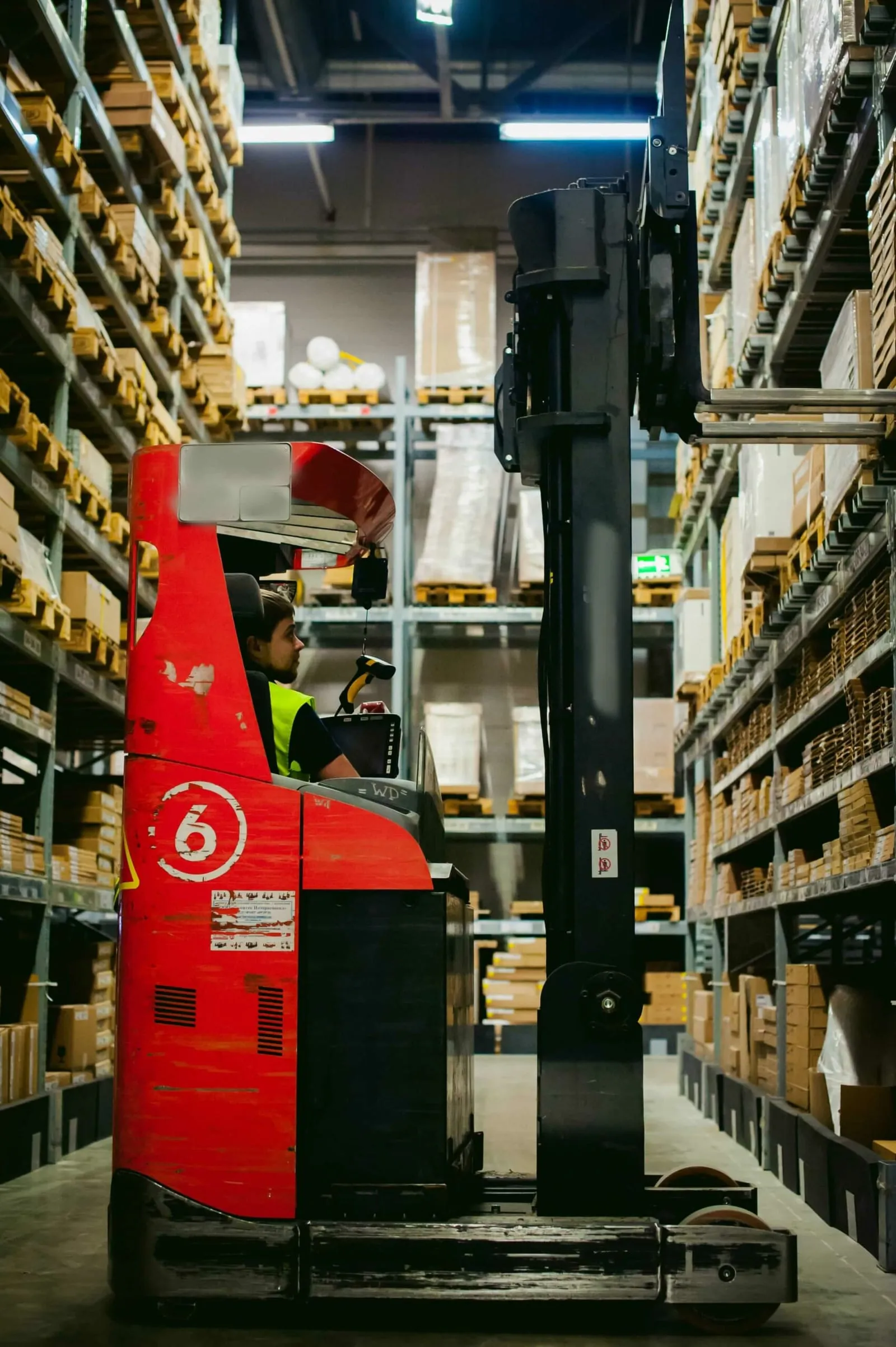 Operator working a very narrow aisle truck between tall racking runs