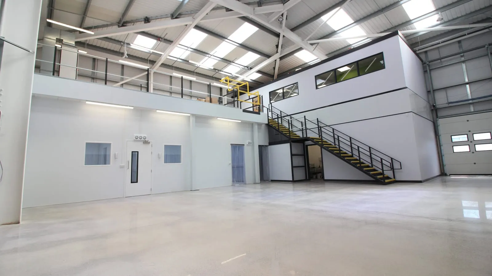 Glazed office block built on a mezzanine deck inside an industrial unit